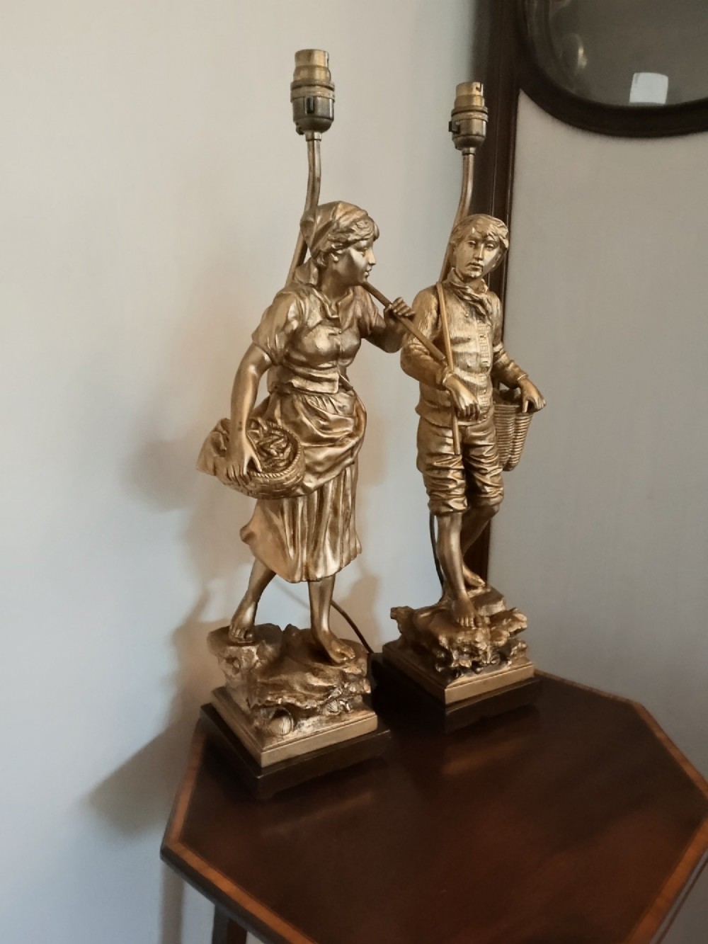 A pair of gold gilt metal table lamps depicting standing figures of French rustic workers mounted on square wooden bases. View XIV