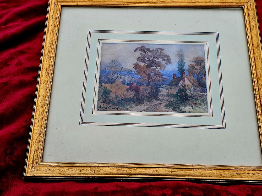 An early 20th-century impressionist watercolour painting depicting a rural country lane with trees and a cottage, framed with a layered mount. View II