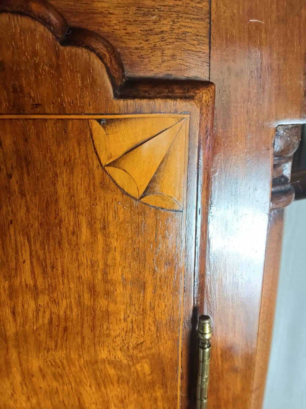 A 19th-century mahogany grandfather clock featuring a swan-neck pediment, brass arch dial, and decorative inlaid paterae on the trunk door. View II