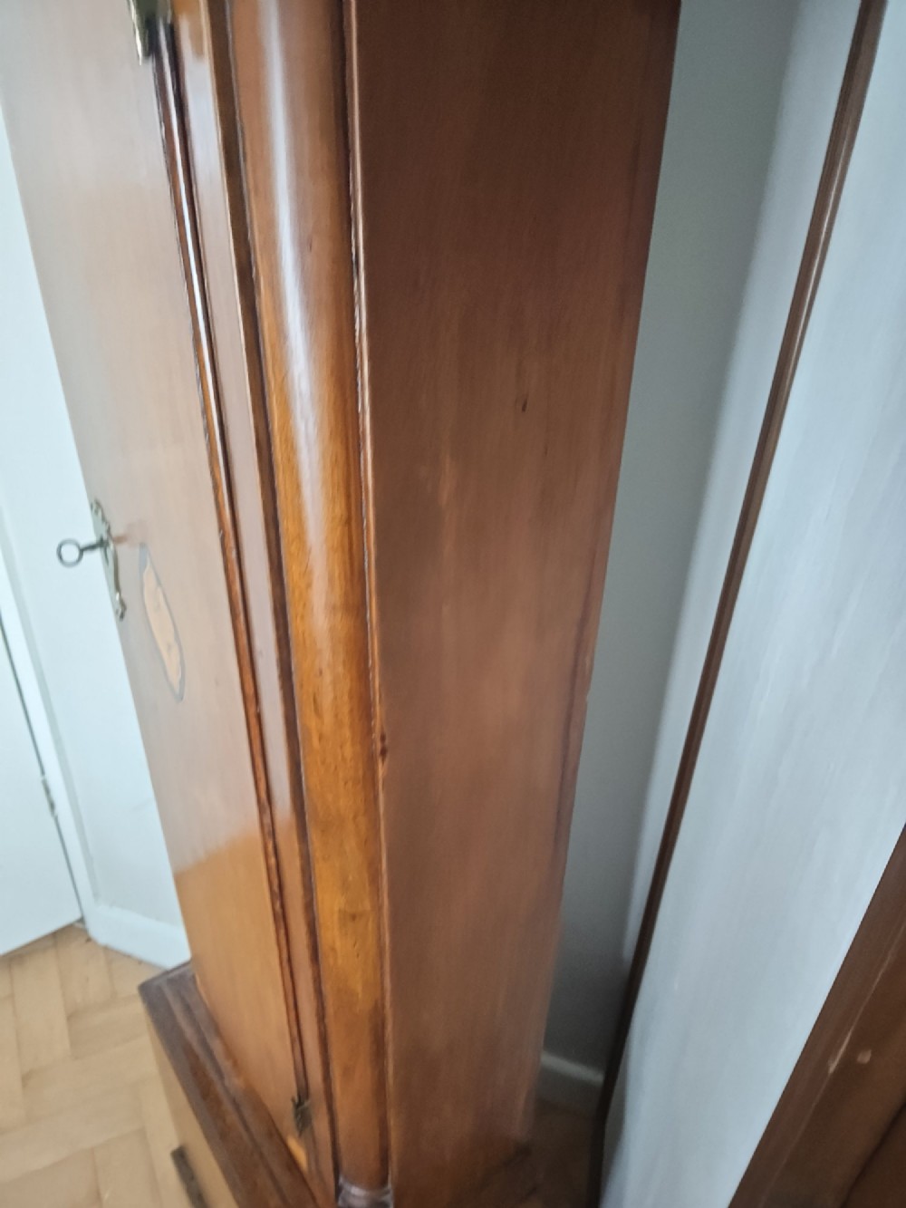 A 19th-century mahogany grandfather clock featuring a swan-neck pediment, brass arch dial, and decorative inlaid paterae on the trunk door. View XI