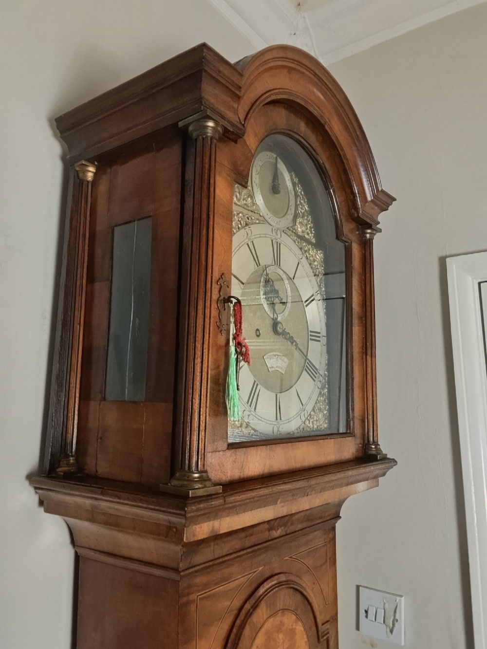 An early Georgian longcase clock featuring a burr walnut veneered case, an arched hood, and a brass dial with Roman numerals. View XV