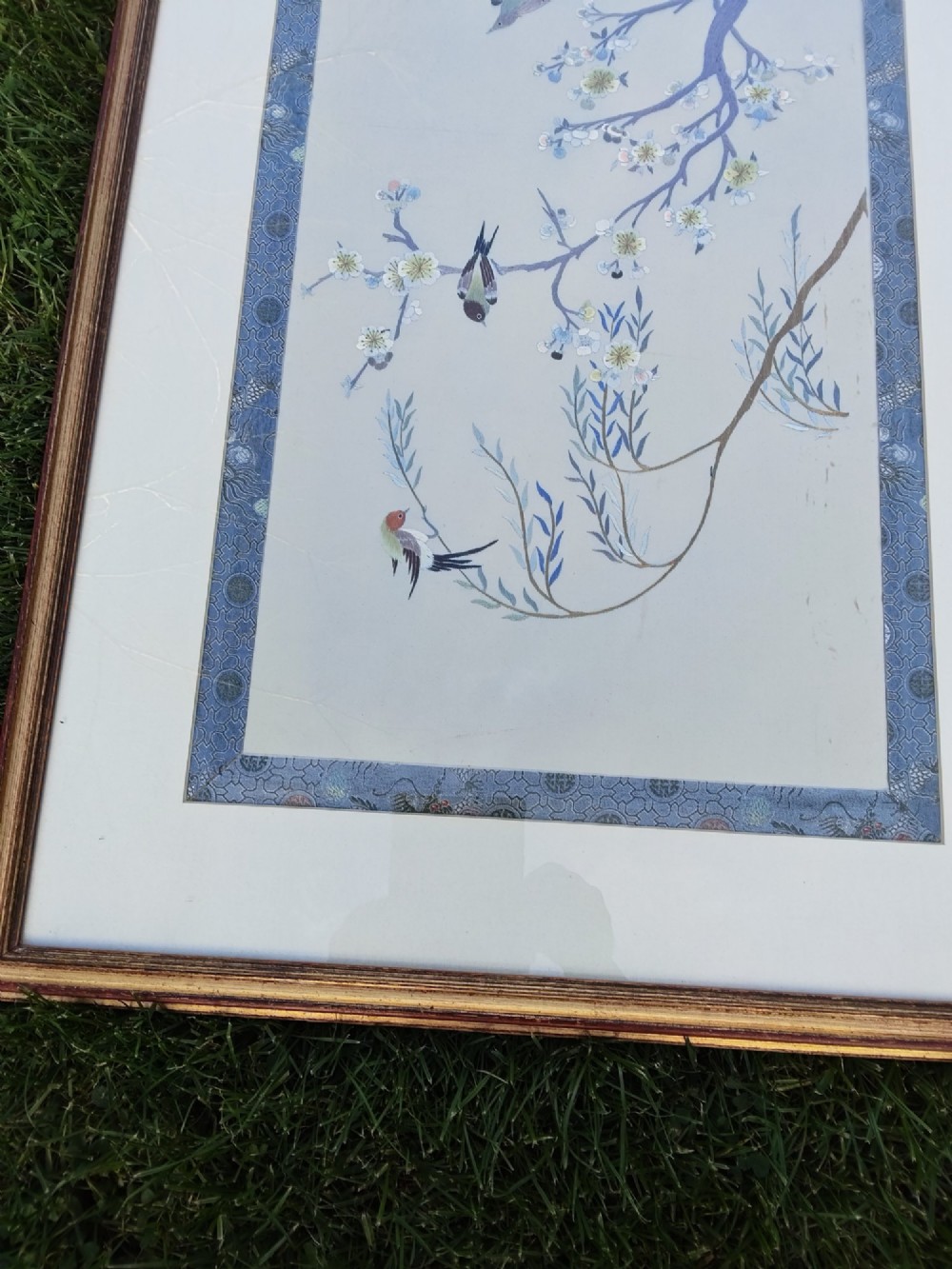 A framed Chinese silk embroidery picture depicting birds perched among blossoming branches and willow leaves on a neutral cream background with a decorative blue brocade border. View VIII