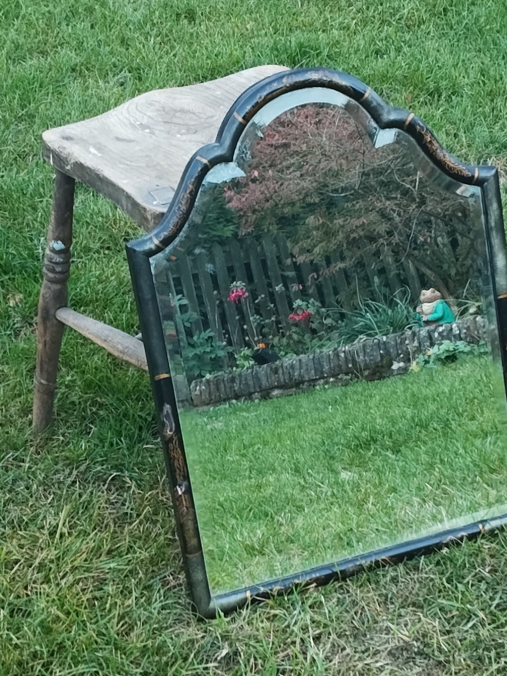 A 19th-century shaped wall mirror featuring a black lacquered frame with hand-painted gold Chinoiserie motifs and a bevelled mirror plate. View III