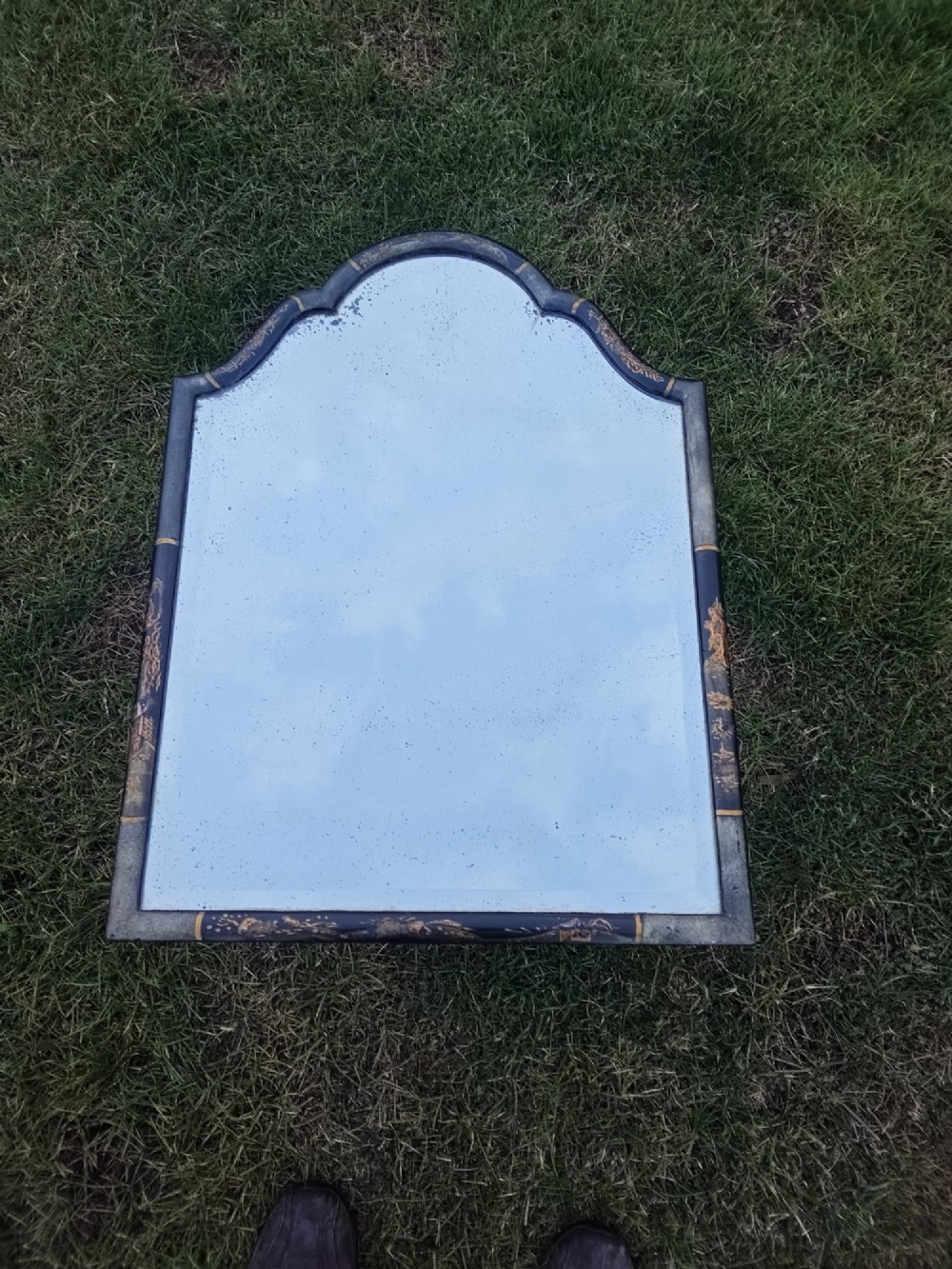 A 19th-century shaped wall mirror featuring a black lacquered frame with hand-painted gold Chinoiserie motifs and a bevelled mirror plate. View IV