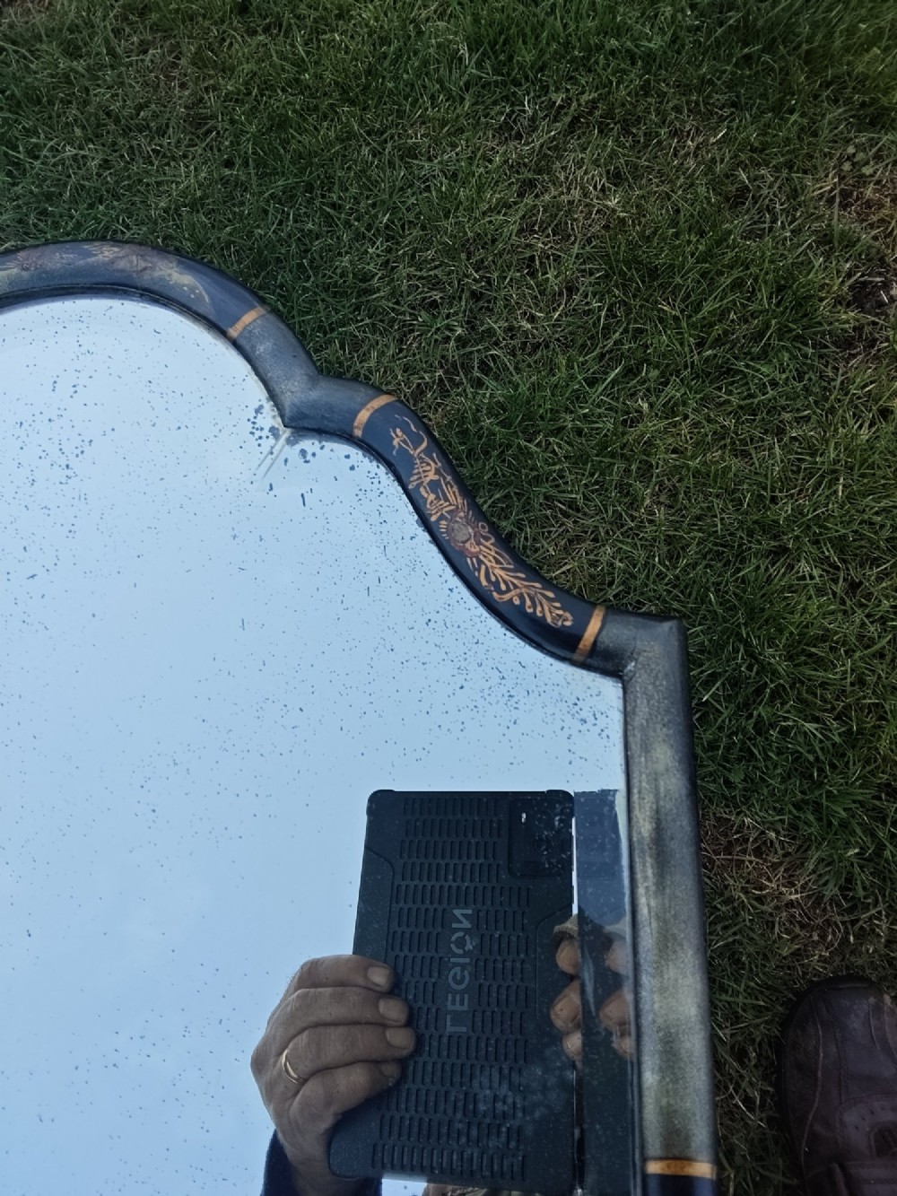 A 19th-century shaped wall mirror featuring a black lacquered frame with hand-painted gold Chinoiserie motifs and a bevelled mirror plate. View VII