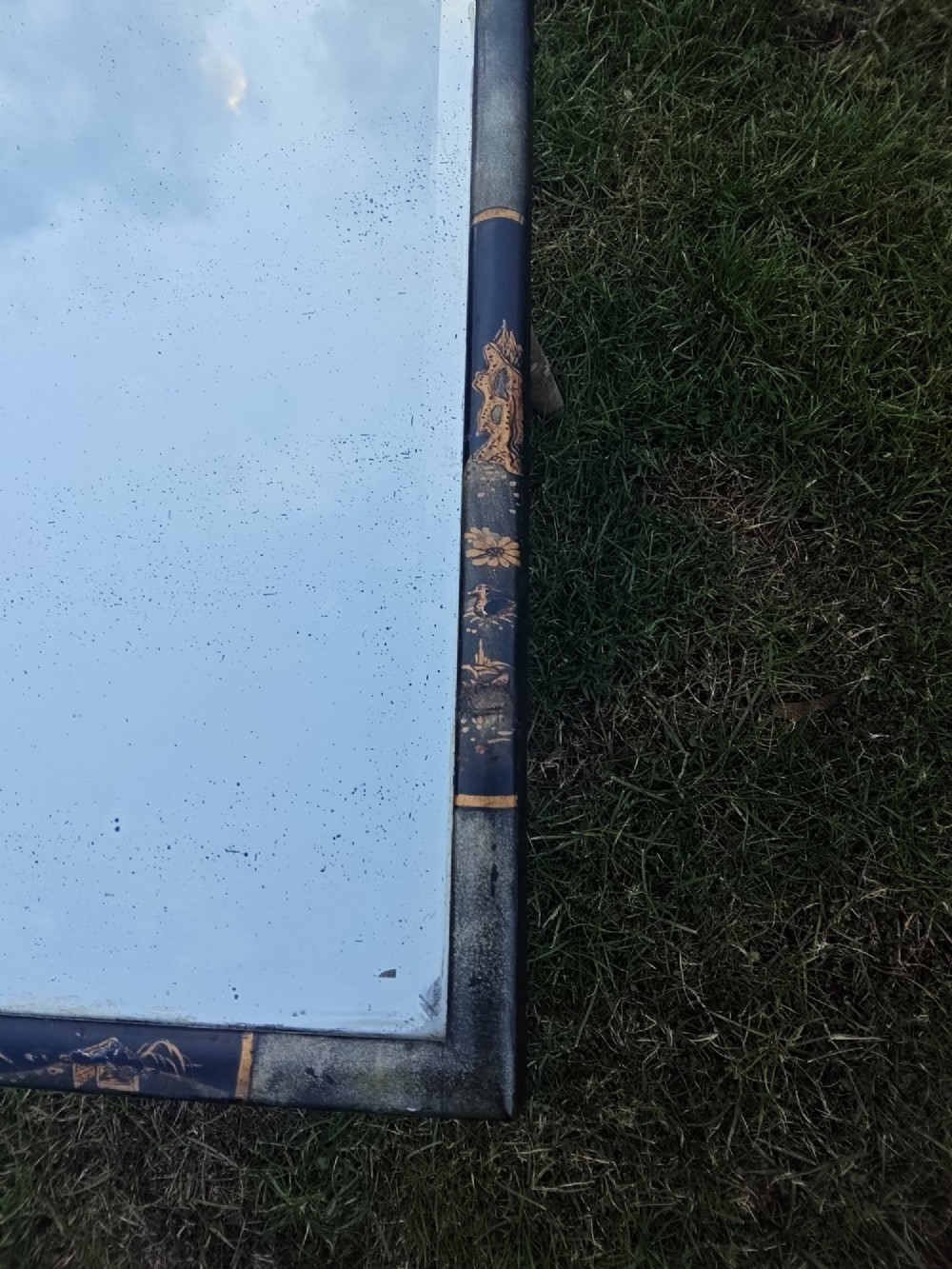 A 19th-century shaped wall mirror featuring a black lacquered frame with hand-painted gold Chinoiserie motifs and a bevelled mirror plate. View VIII