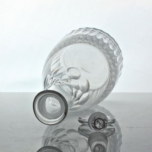 fig 1. A clear Georgian cut glass spirit decanter featuring vertical fluted cuts along the base, facet cutting on the upper neck, and a faceted round stopper.