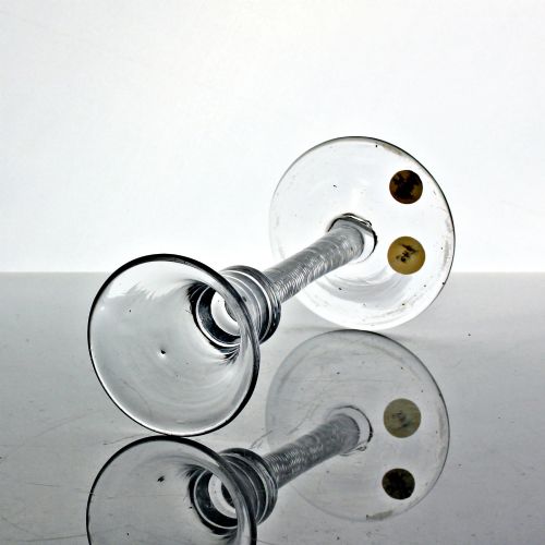 fig 1. An eighteenth-century clear lead glass wine glass featuring a waisted bucket bowl, a multi-spiral air twist stem, and a flat conical foot.
