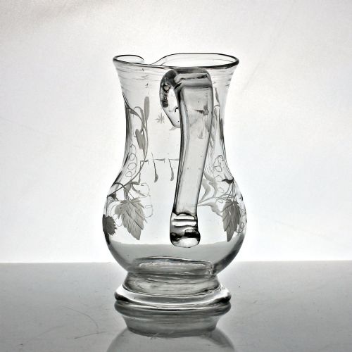 fig 1. A clear glass Georgian jug decorated with wheel-engraved hop and barley motifs and fitted with an applied loop handle.