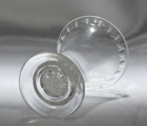 fig 1. A Georgian clear glass jelly vessel featuring a flared rim, faint engraved detailing, and a short knopped stem with an embedded white opaque twist set above a circular foot.