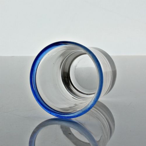 fig 1. A small clear hand-blown glass tumbler featuring an applied cobalt blue glass rim around the top opening.