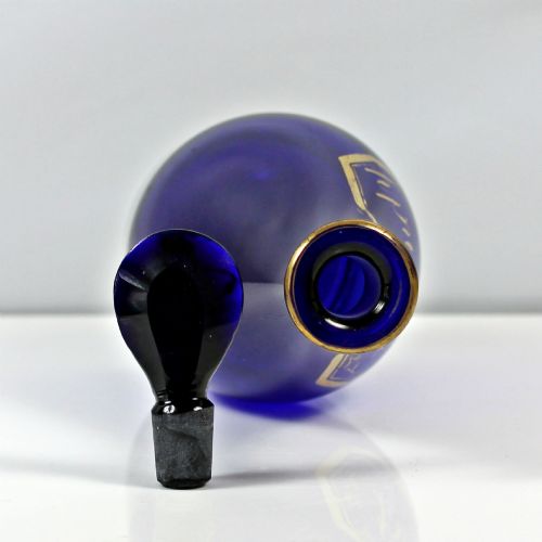 fig 1. A Georgian cobalt blue glass brandy decanter featuring a tapered body with gilded lettering reading Brandy and a matching lozenge stopper.