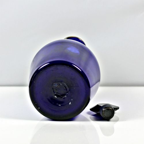 fig 2. A Georgian cobalt blue glass brandy decanter featuring a tapered body with gilded lettering reading Brandy and a matching lozenge stopper.