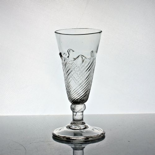 fig 1. A clear Georgian hand-blown dwarf ale glass featuring a funnel-shaped bowl with diagonal flammiform moulding on a short knopped stem and conical foot.