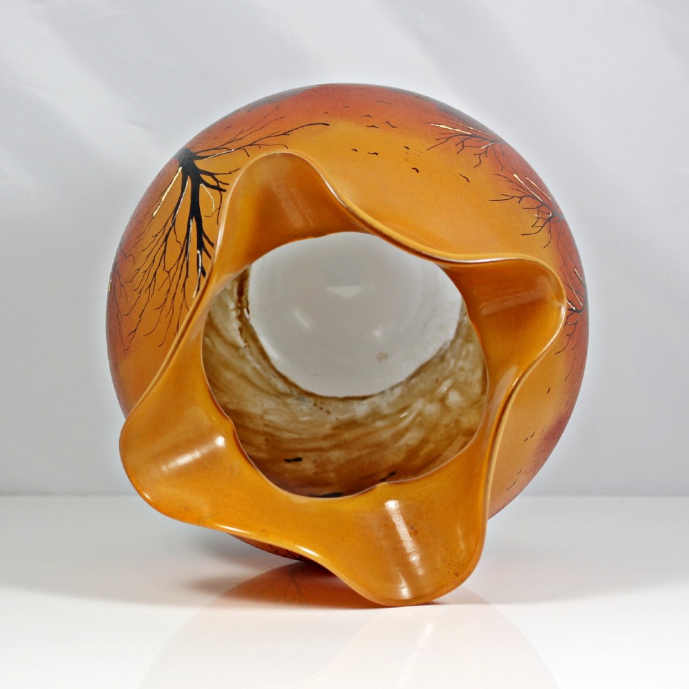 A globular Art Nouveau glass vase featuring an amber to orange gradient body, a ruffled rim, and a painted winter landscape with bare trees and textured white snow along the base. View V
