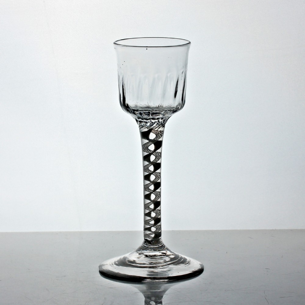 An 18th-century Georgian clear glass wine stemware with a flute-moulded ogee bowl, an opaque white twist stem, and a wide conical foot. View II