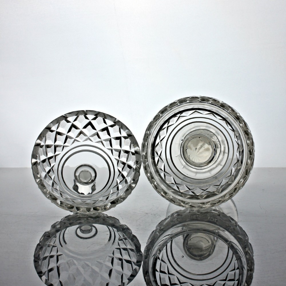 An Edwardian clear cut glass lidded bowl featuring diamond facets, a pedestal stem, and a faceted top finial. View V