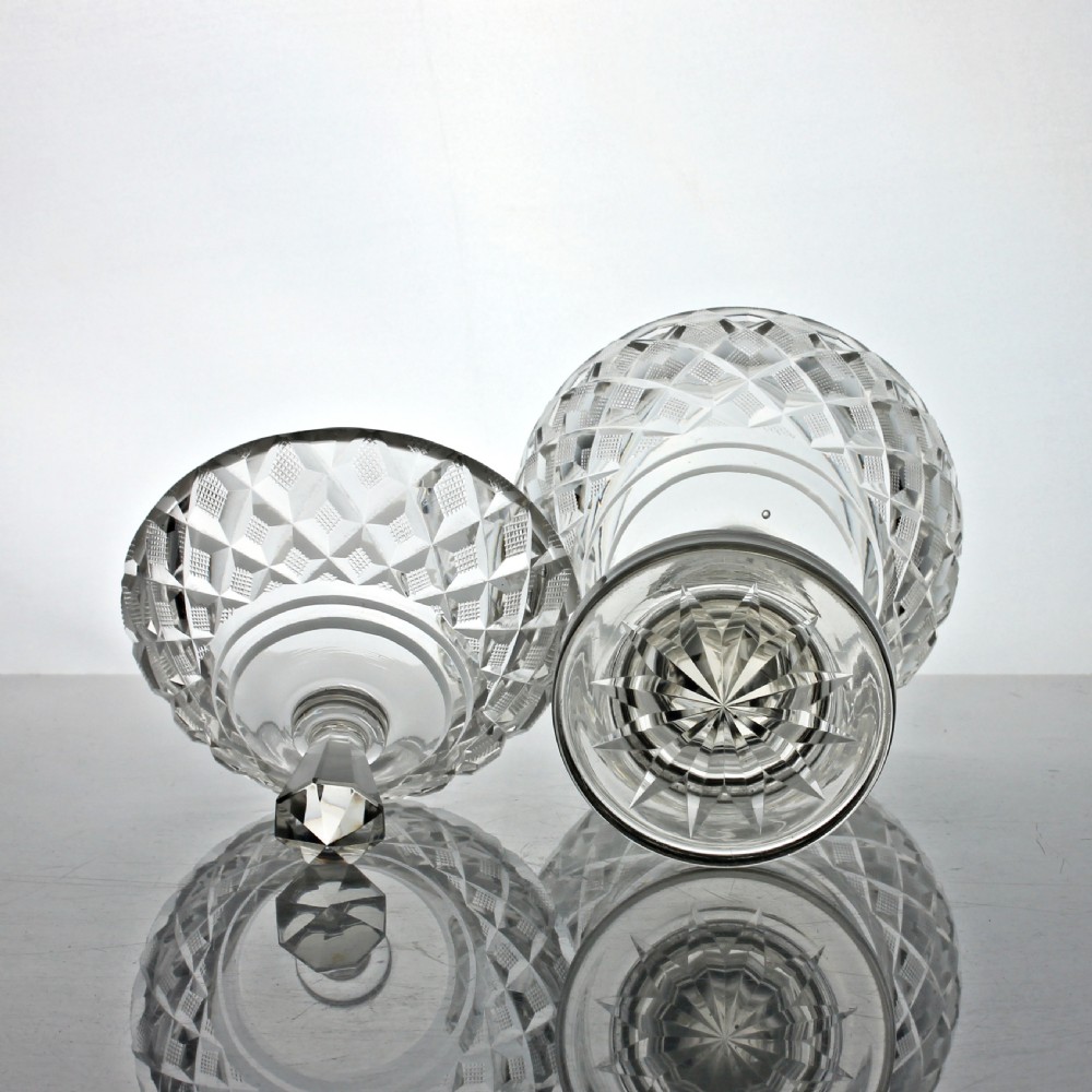 An Edwardian clear cut glass lidded bowl featuring diamond facets, a pedestal stem, and a faceted top finial. View VI