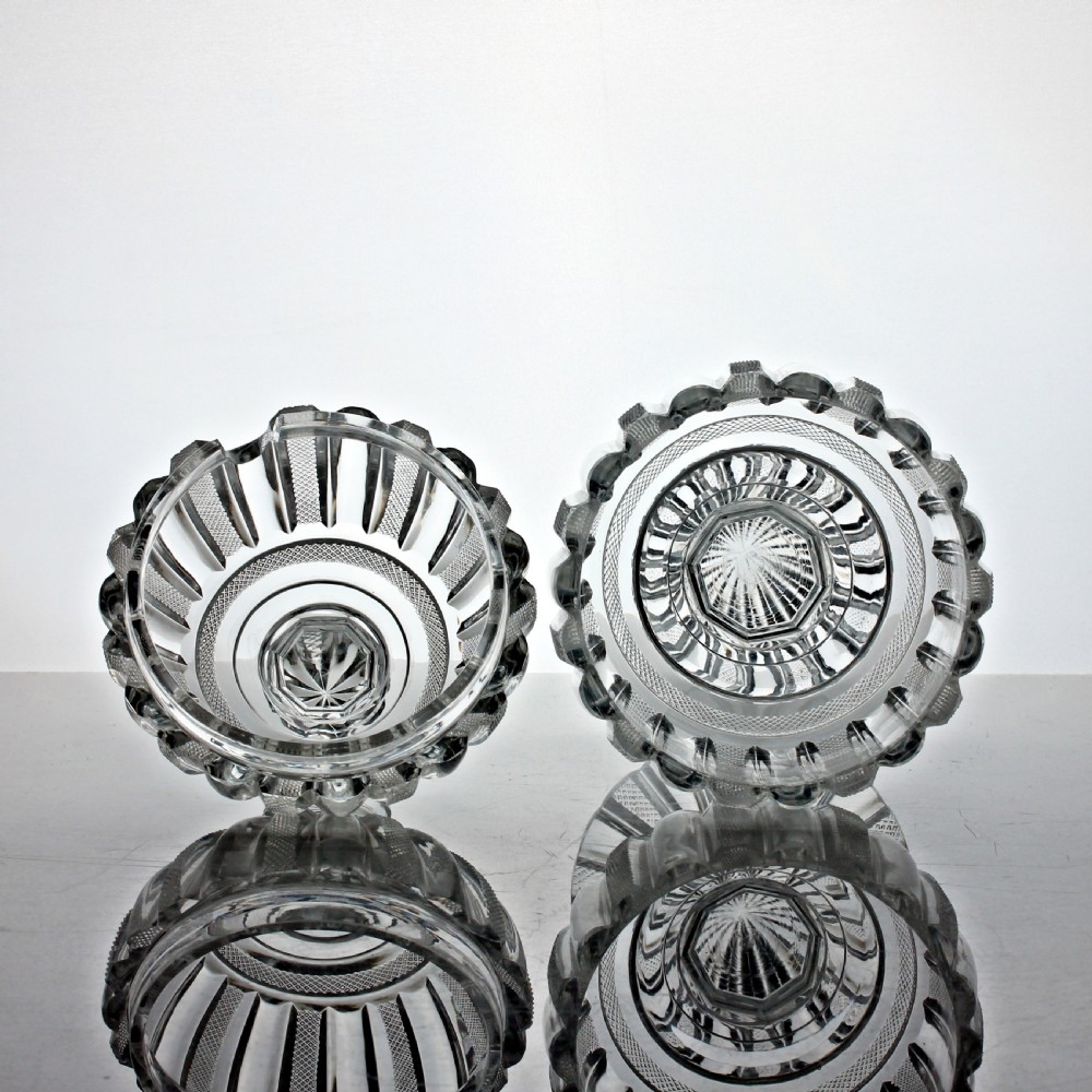 A clear cut glass preserve pot with a fitted lid and knopped finial resting on a matching scalloped glass saucer base. View III