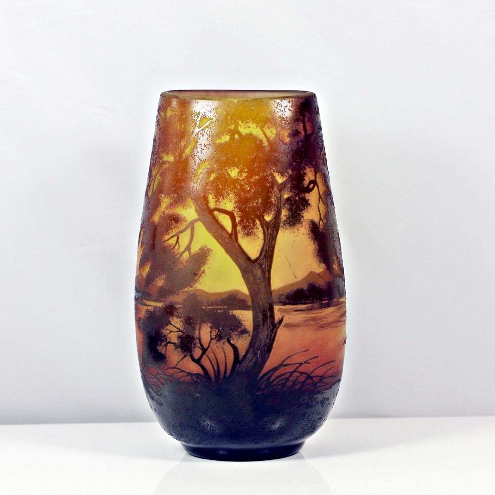An Art Nouveau cameo glass vase featuring an acid-etched sunset landscape scene with trees, water, and birds in shades of amber, yellow, and dark brown. View II