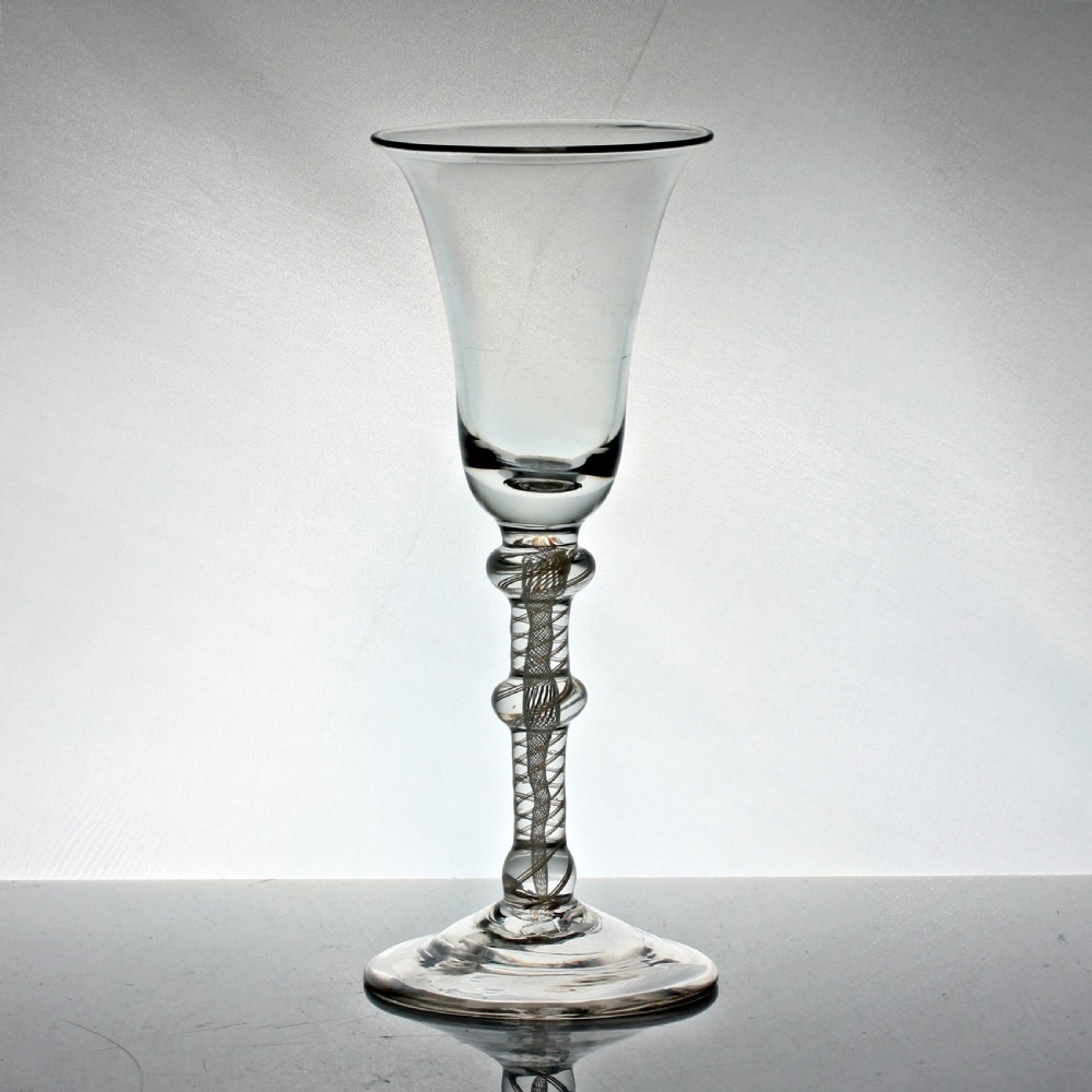 A Georgian clear glass wine goblet featuring a flared bell bowl and a triple-knopped stem with an internal white opaque twist pattern. View II