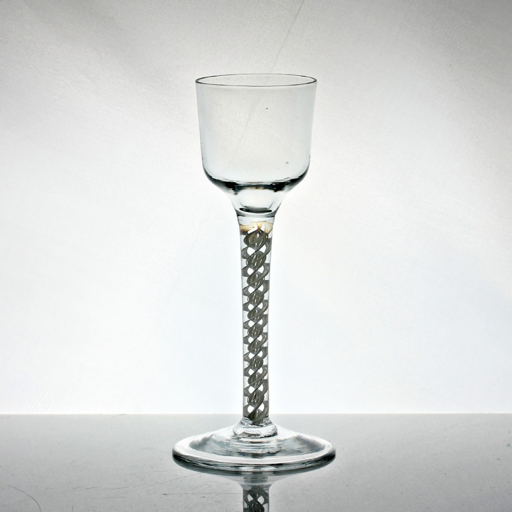 A Georgian clear glass wine glass featuring a bell-shaped bowl, a long stem with an internal white opaque twist pattern, and a conical foot. View II