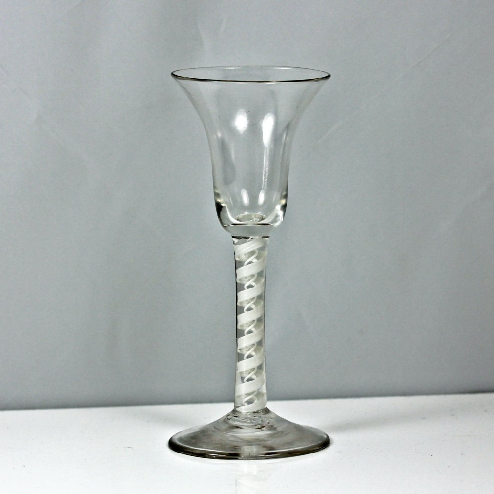 A Georgian clear glass wine glass featuring a flared bell bowl and an internal double series white opaque twist stem.
