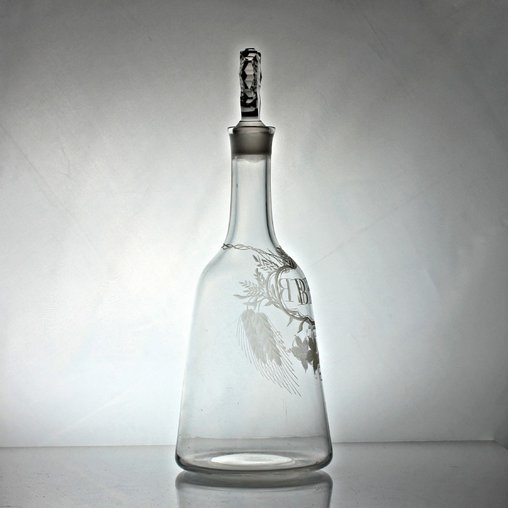 A clear Georgian sugarloaf glass decanter featuring wheel-engraved foliage, a cartouche inscribed with the word BEER, and a faceted stopper. View III
