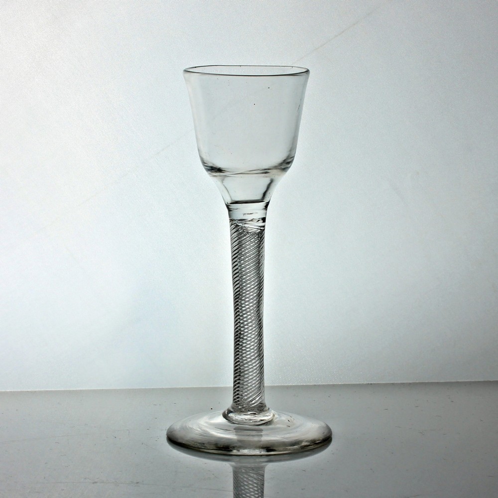 A clear Georgian wine glass featuring an ogee-shaped bowl, a multi-spiral air twist stem, and a flat circular foot.