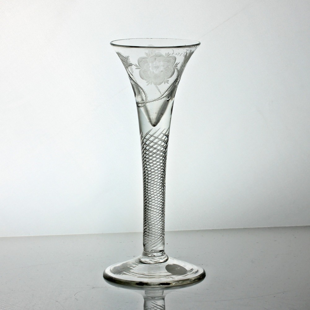 A clear Georgian air twist wine glass featuring a trumpet-shaped bowl with wheel-engraved rose motifs and a multi-spiral twist stem.
