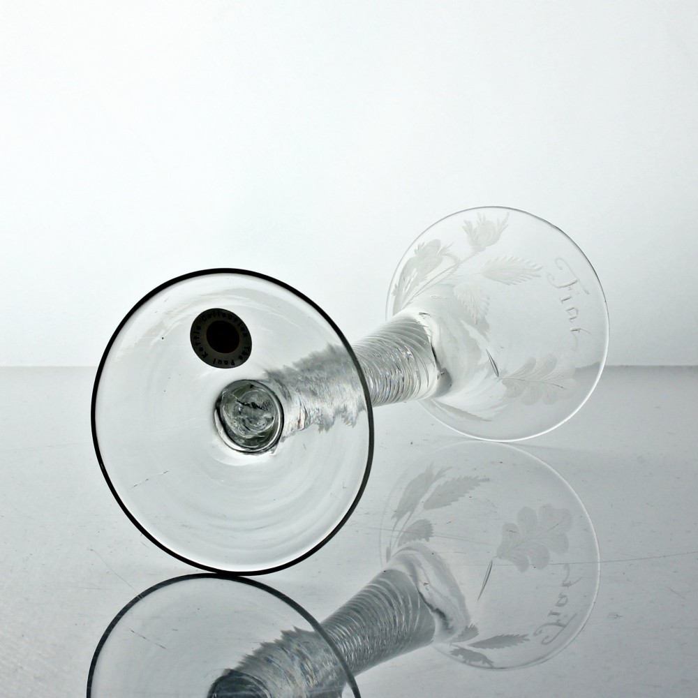 A clear Georgian air twist wine glass featuring a trumpet-shaped bowl with wheel-engraved rose motifs and a multi-spiral twist stem. View VII