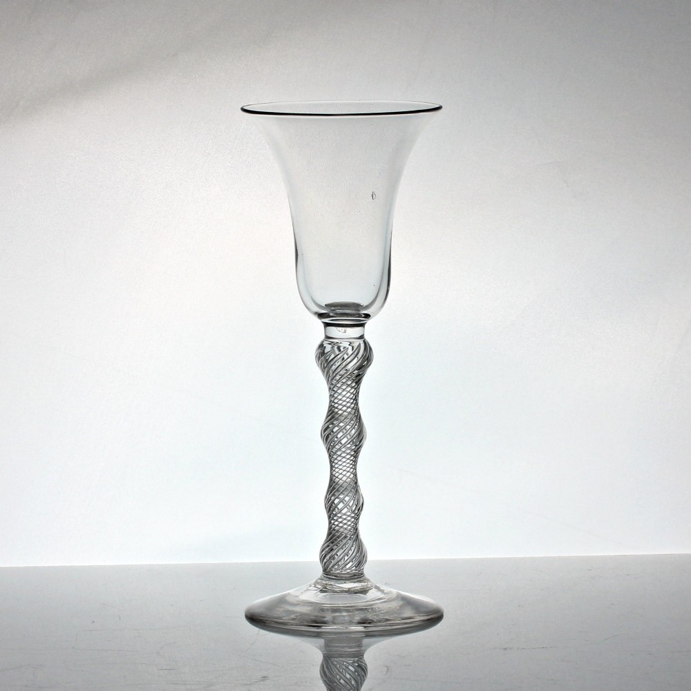A Georgian clear glass wine goblet featuring a flared bell bowl resting on a multi-spiral air twist stem with four knops over a conical foot.