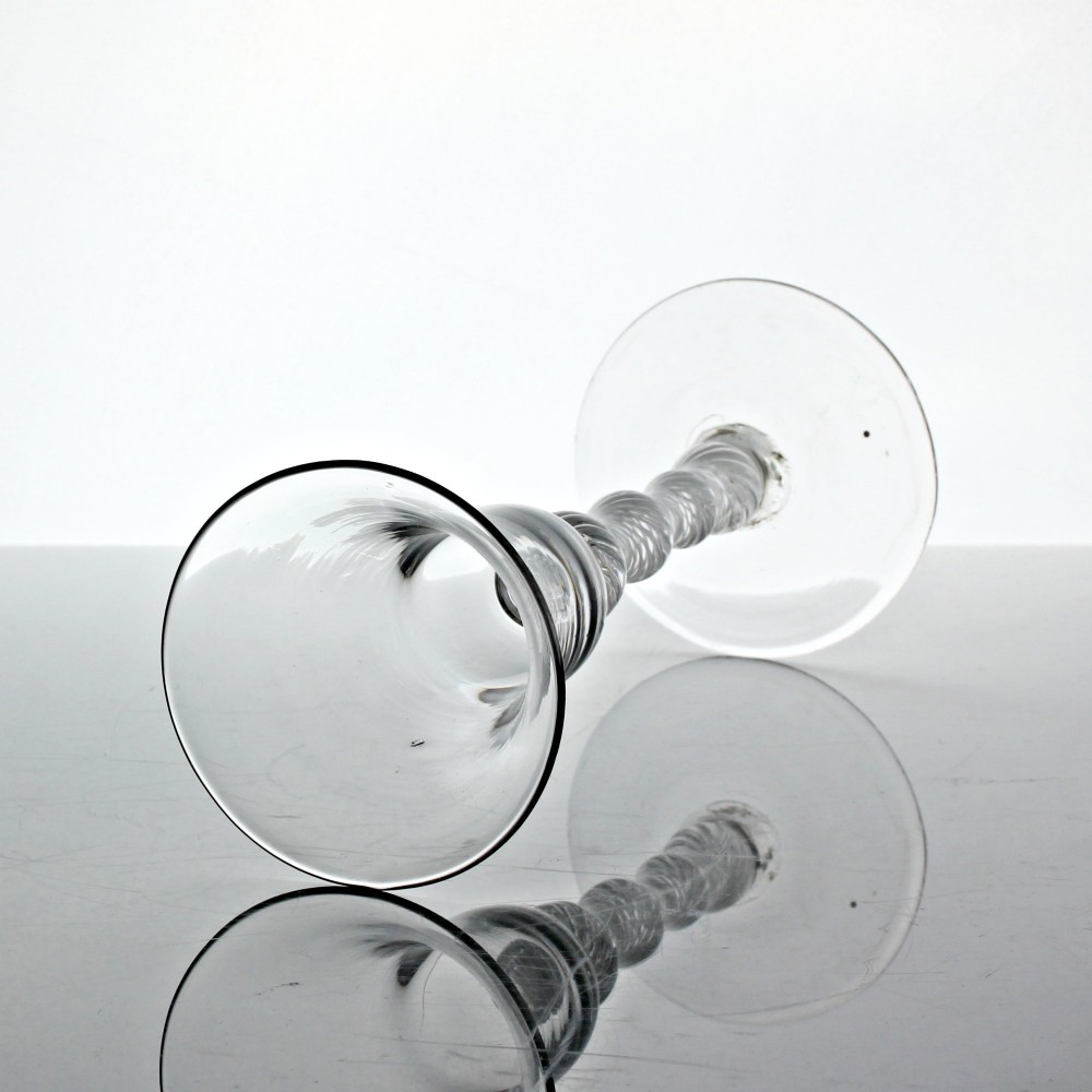 A Georgian clear glass wine goblet featuring a flared bell bowl resting on a multi-spiral air twist stem with four knops over a conical foot. View II