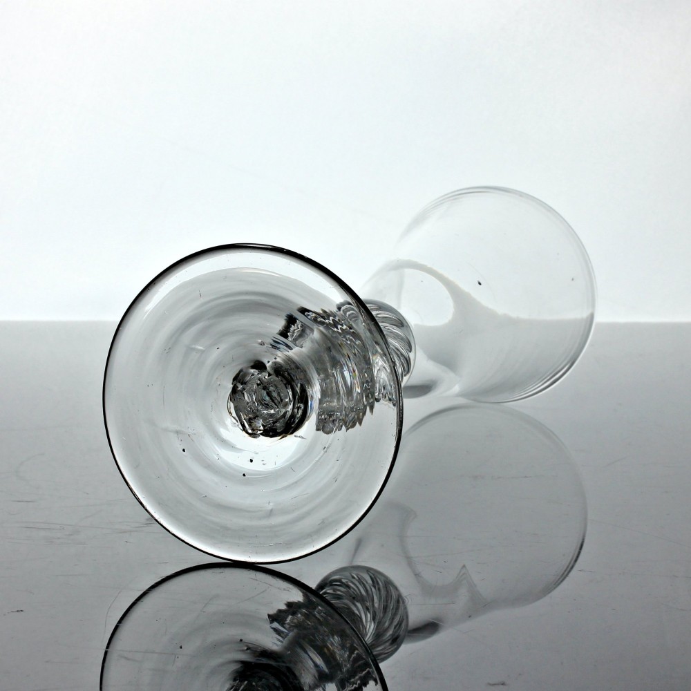 A tall clear glass featuring a conical bowl, a multi-spiral air twist stem with knops, and a circular flat foot. View III