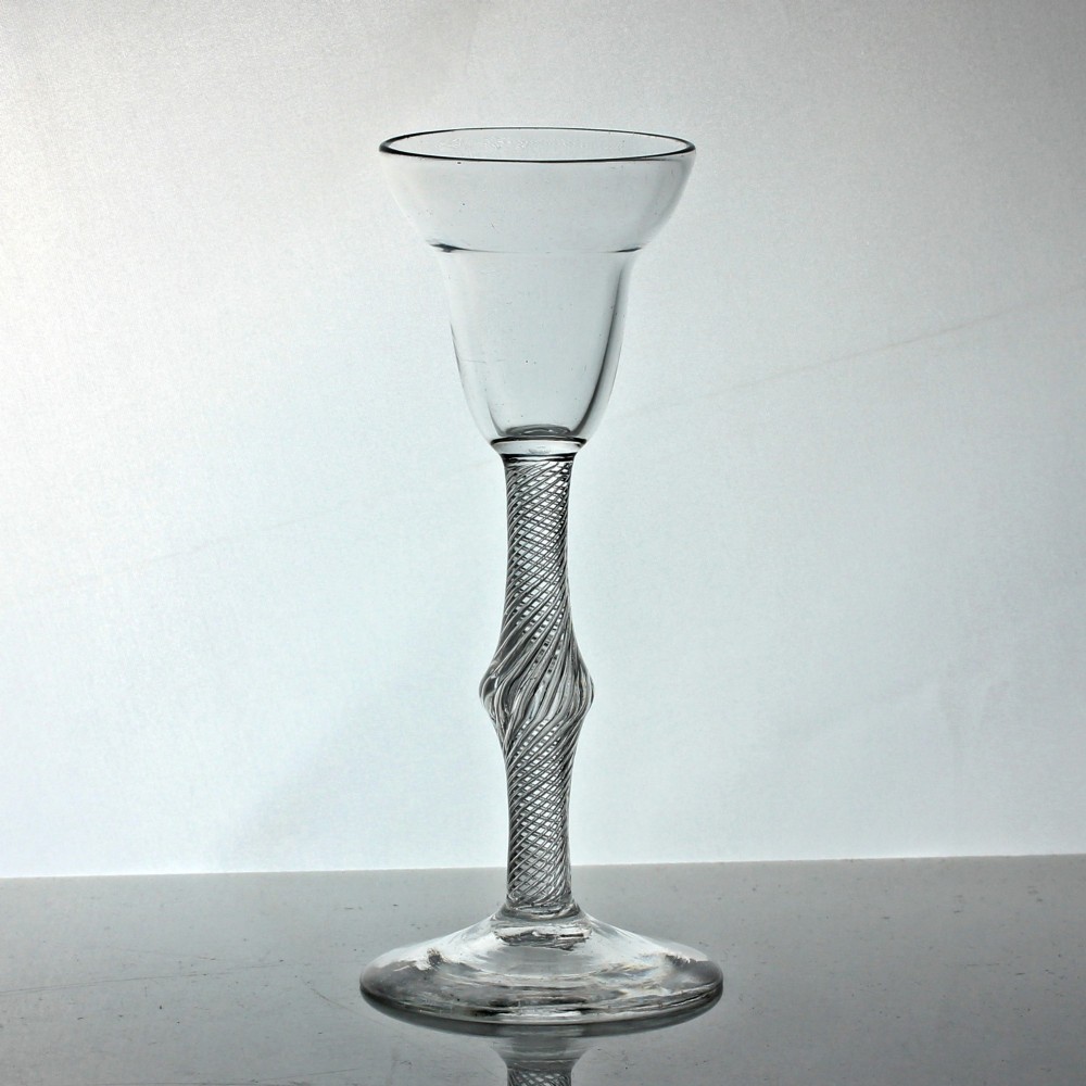 A Georgian clear lead glass wine glass featuring a pan top bowl resting on a multi-spiral air twist stem with a central knop and a wide conical foot.