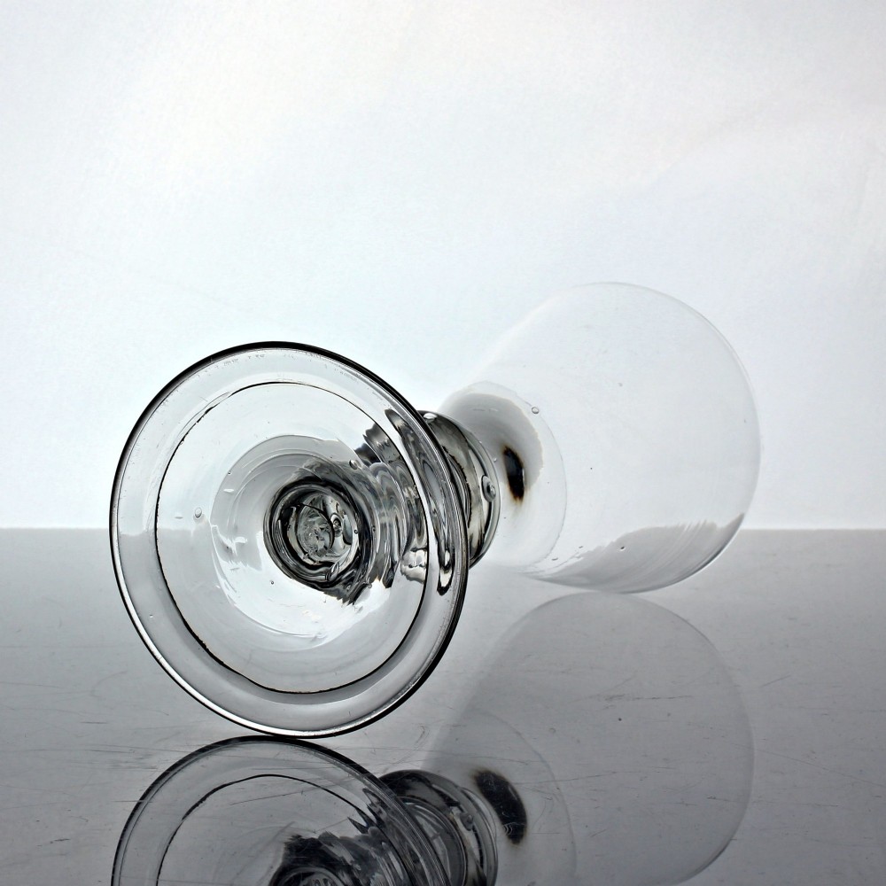 An antique clear glass wine goblet featuring a conical bowl, a stem with a triple annular knop containing an air bubble tear, resting on a wide circular foot. View III
