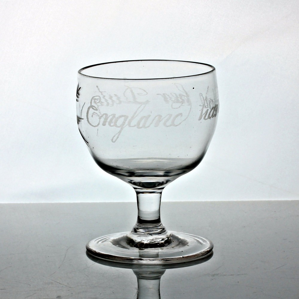 A clear Georgian glass rummer with wheel-engraved script reading England has done her duty set on a short stem and circular foot.