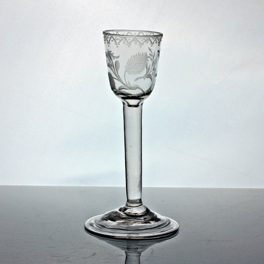 An 18th-century Georgian clear lead glass wine glass featuring a plain stem, circular base, and wheel-engraved floral motif on the bowl. View II