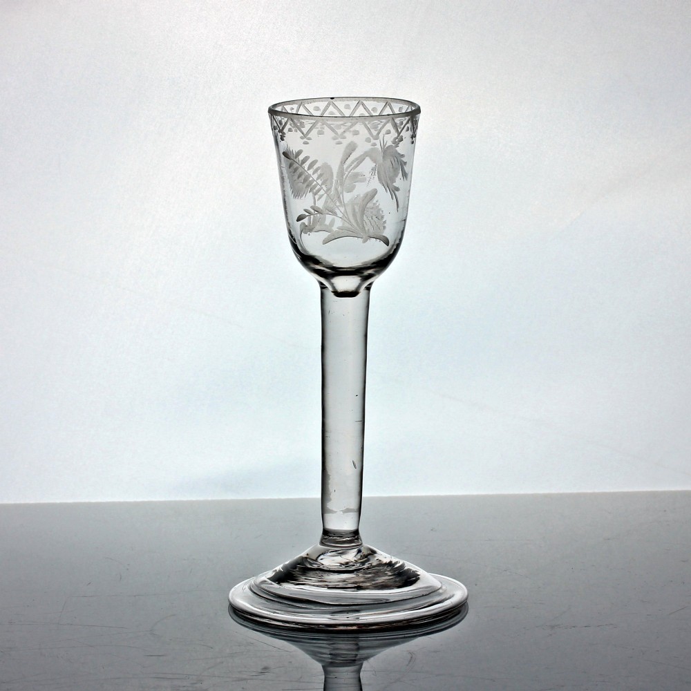 An 18th-century Georgian clear lead glass wine glass featuring a plain stem, circular base, and wheel-engraved floral motif on the bowl. View III