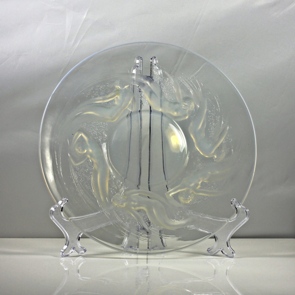 A circular Rene Lalique opalescent glass dish featuring a relief pattern of six swirling female nudes surrounding a smooth central recess. View II