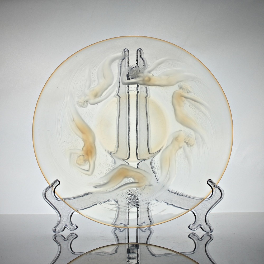 A circular Rene Lalique opalescent glass dish featuring a relief pattern of six swirling female nudes surrounding a smooth central recess. View V