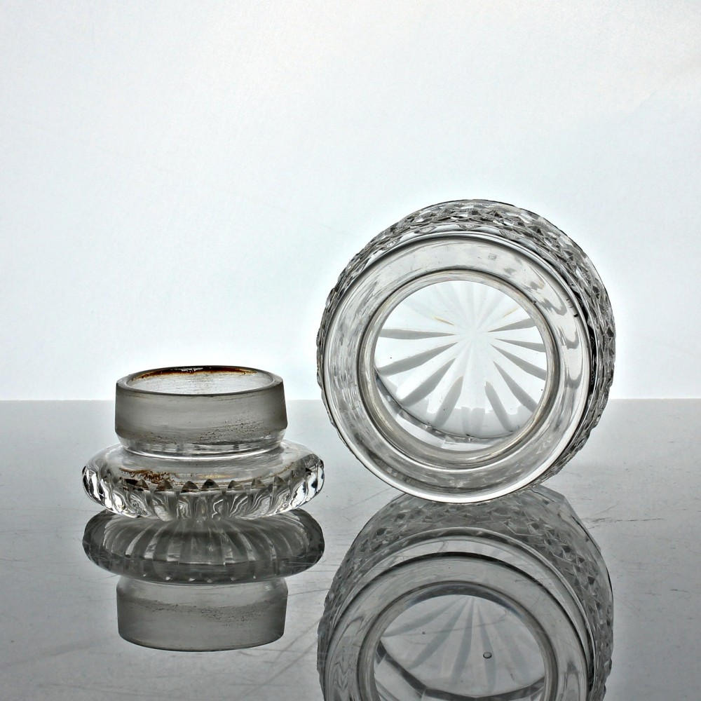 A clear Georgian cut glass cylindrical pickle jar featuring strawberry diamond cutting and a matching fitted glass lid. View II