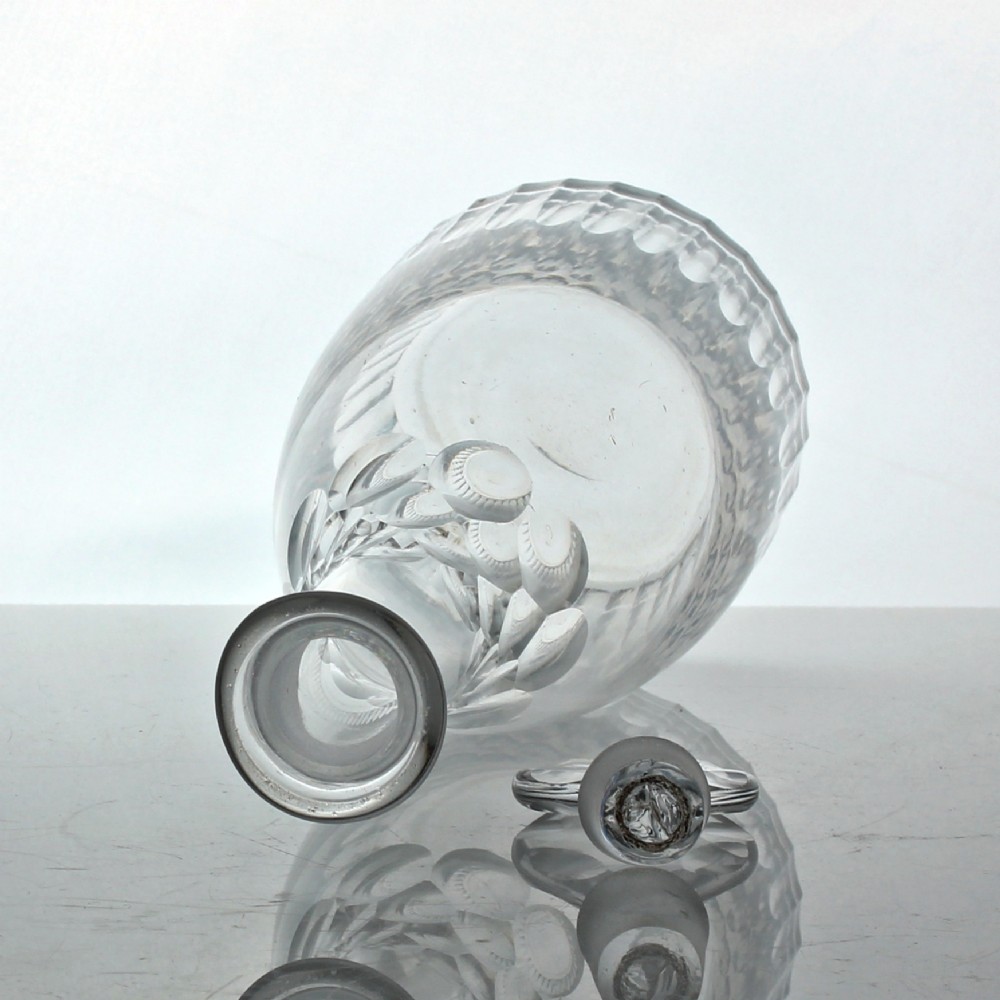 A clear Georgian cut glass spirit decanter featuring vertical fluted cuts along the base, facet cutting on the upper neck, and a faceted round stopper. View II