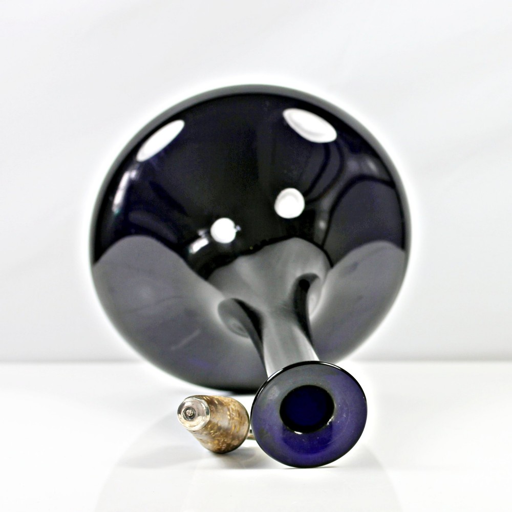 A pair of deep cobalt Bristol blue glass mell-shaped decanters featuring slender necks and metal ring stoppers labelled Claret and Brandy. View VI