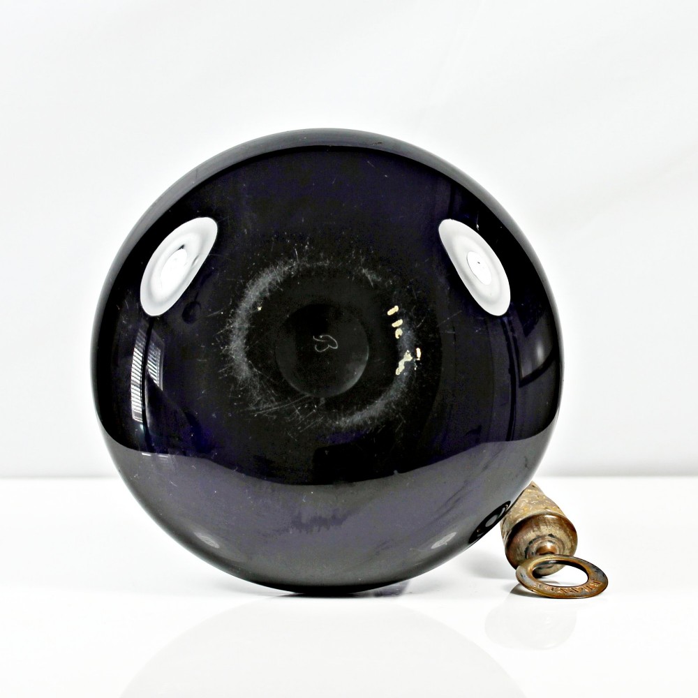 A pair of deep cobalt Bristol blue glass mell-shaped decanters featuring slender necks and metal ring stoppers labelled Claret and Brandy. View VII