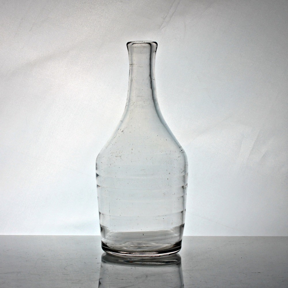 A clear lead glass Georgian shoulder carafe featuring a flared neck and five horizontal raised Lynn rings around the lower body.