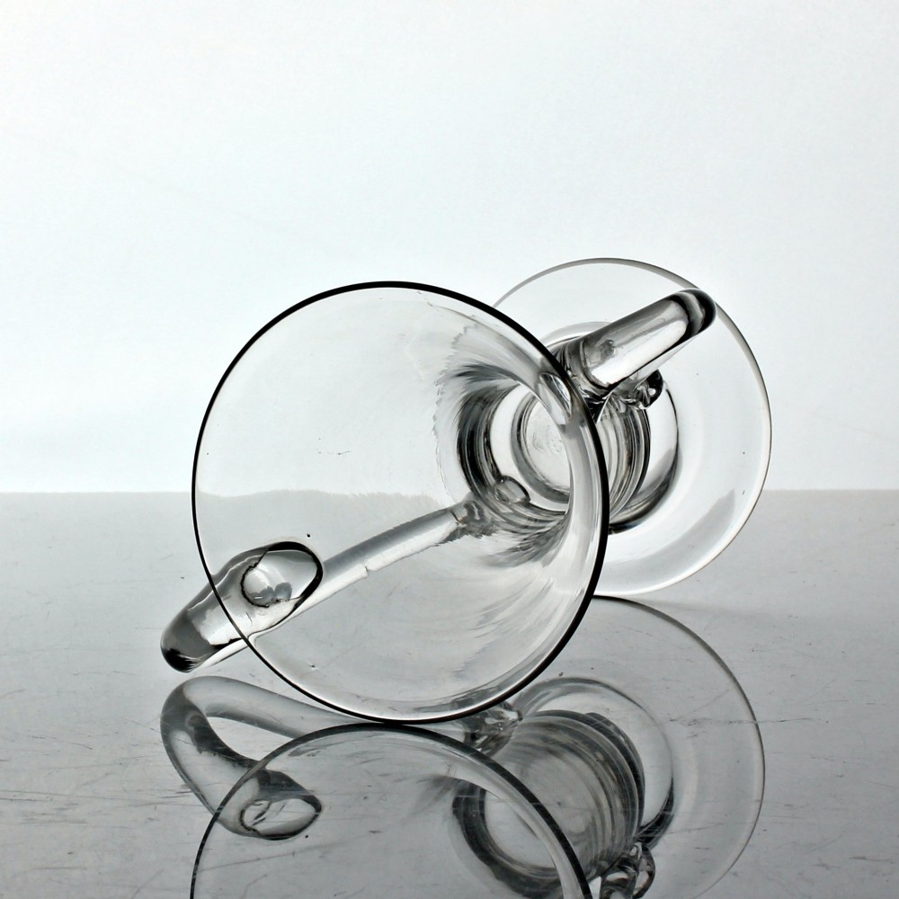 A clear Georgian hand-blown glass cup featuring two curved side handles, a flared rim, and a thick pedestal base. View IV