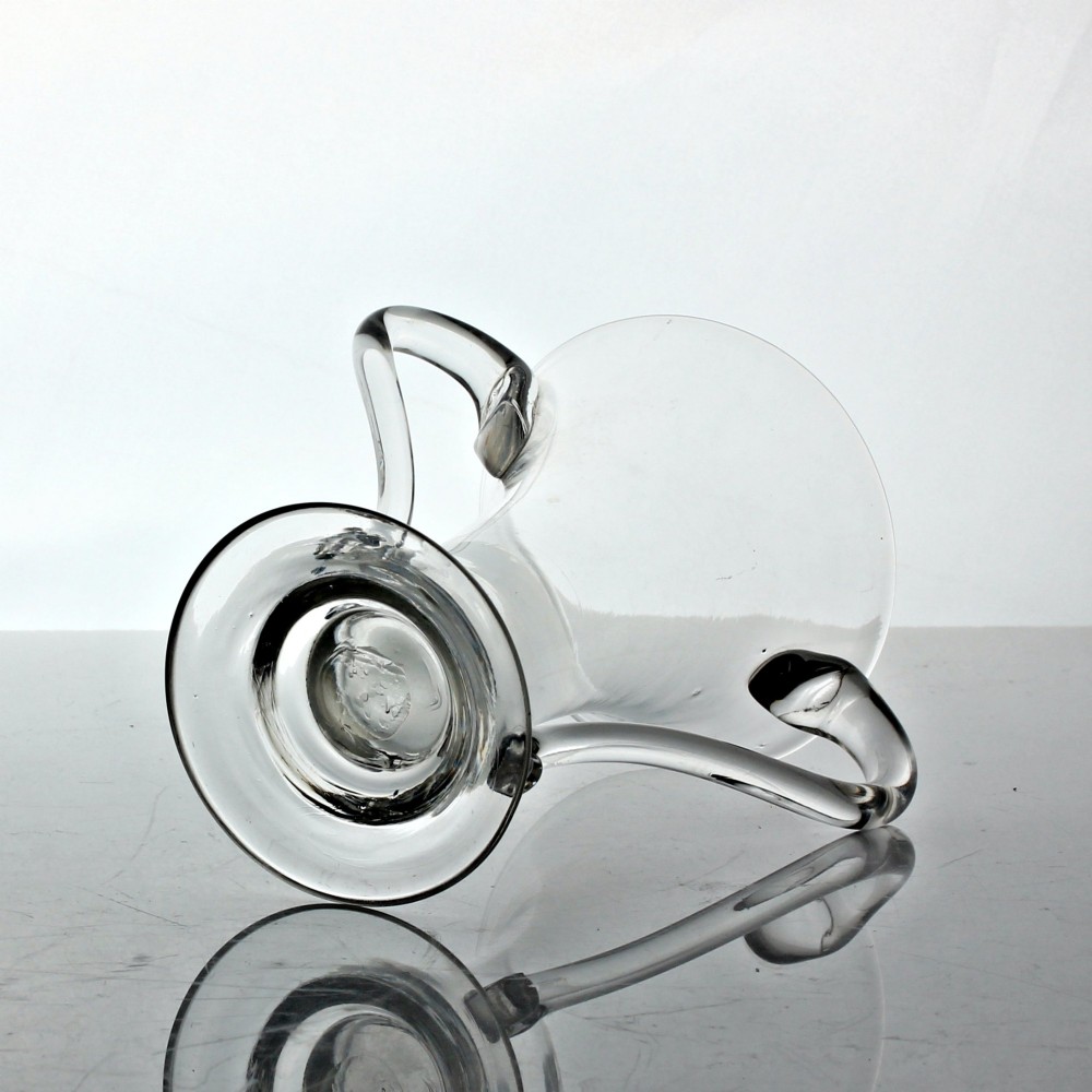A clear Georgian hand-blown glass cup featuring two curved side handles, a flared rim, and a thick pedestal base. View V
