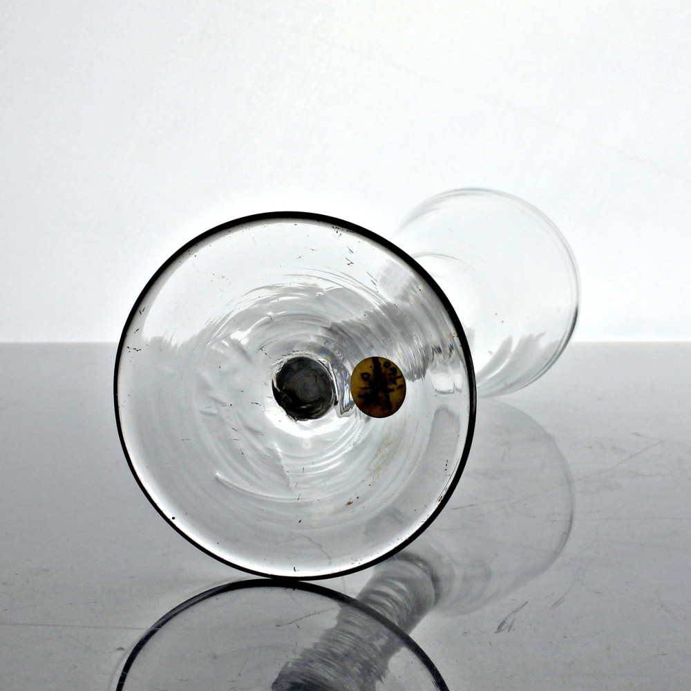 An antique clear glass wine glass featuring a bell-shaped bowl, an internal white opaque twist stem, and a flat conical base. View IV