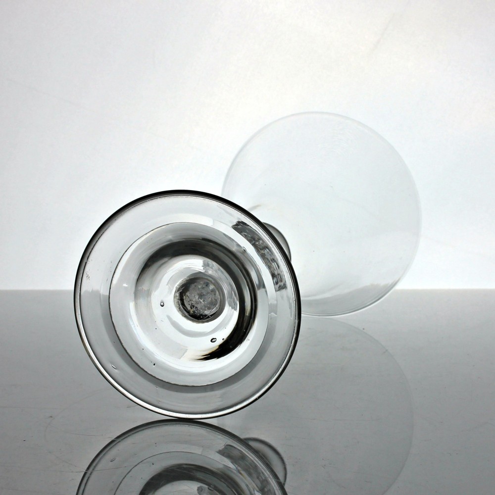 A clear Georgian glass goblet featuring a bell-shaped bowl, a turned baluster stem with knops, and a domed circular foot. View III